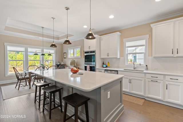 kitchen featuring white cabinets, appliances with stainless steel finishes, sink, and a center island