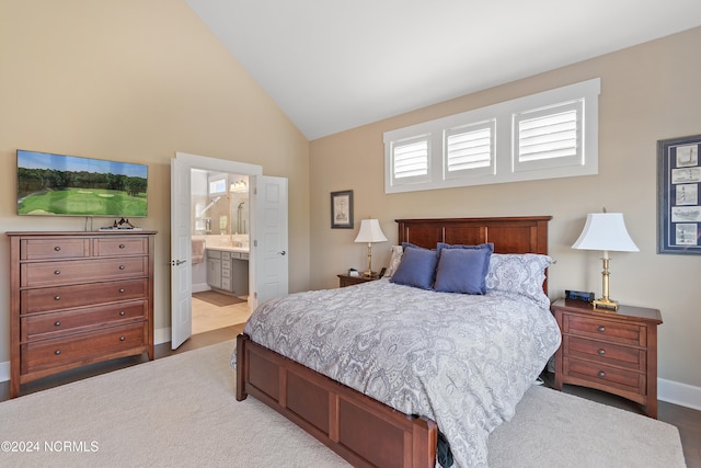 bedroom with ensuite bathroom and high vaulted ceiling