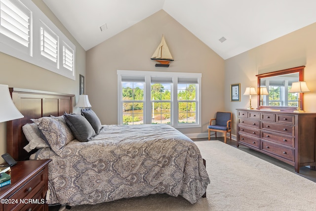 carpeted bedroom featuring high vaulted ceiling