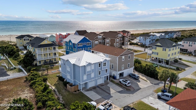 birds eye view of property featuring a water view and a beach view