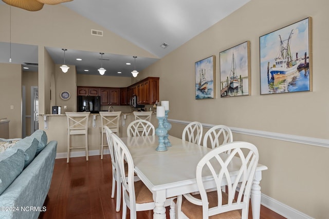 dining space featuring dark wood-type flooring and high vaulted ceiling