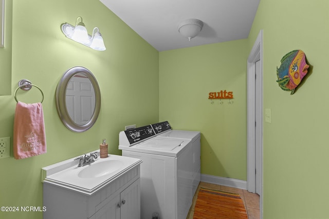 laundry area featuring light tile patterned flooring, sink, and separate washer and dryer