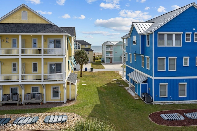 exterior space with a balcony, central air condition unit, and a lawn