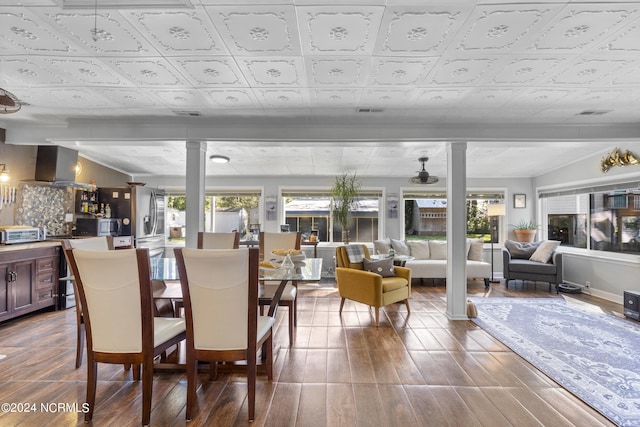 dining area featuring wood-type flooring and ornate columns