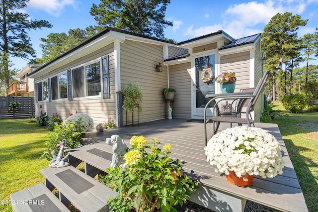 wooden deck featuring a lawn