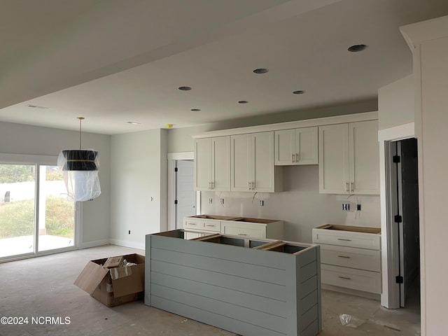 kitchen featuring white cabinets, pendant lighting, and a kitchen island