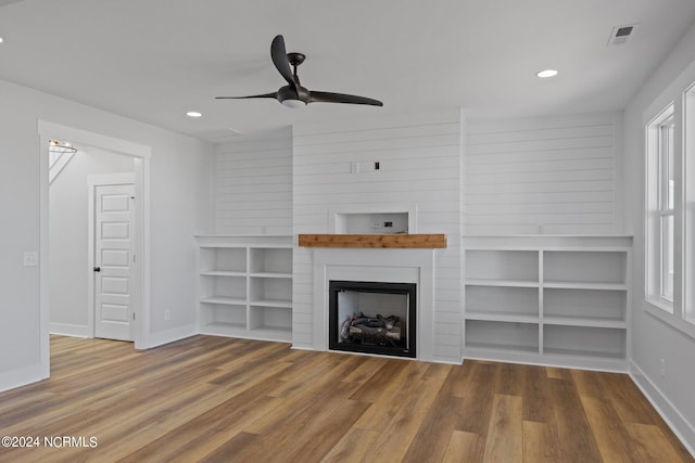 unfurnished living room featuring hardwood / wood-style floors, a fireplace, and ceiling fan