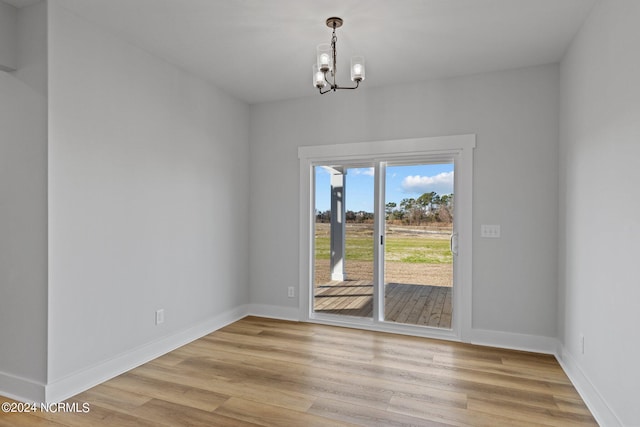 unfurnished dining area with light hardwood / wood-style flooring and an inviting chandelier