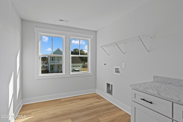 washroom featuring electric dryer hookup, light hardwood / wood-style floors, and hookup for a washing machine