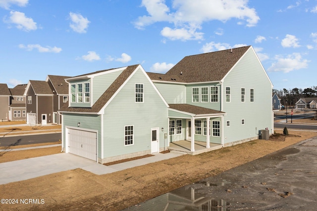 rear view of property featuring cooling unit and a garage