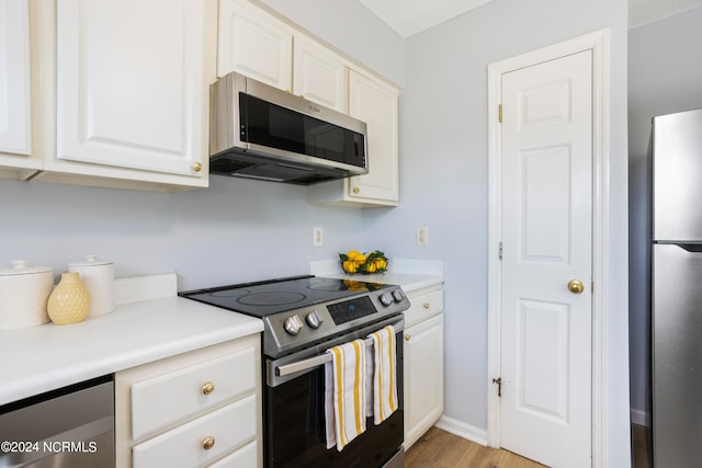 kitchen with white cabinetry, light hardwood / wood-style floors, and appliances with stainless steel finishes