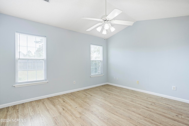 unfurnished room with light hardwood / wood-style floors, lofted ceiling, a healthy amount of sunlight, and ceiling fan