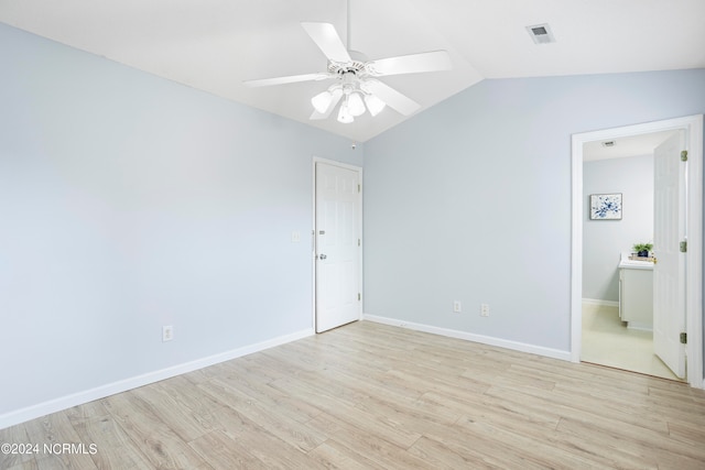 unfurnished bedroom featuring ceiling fan, vaulted ceiling, light wood-type flooring, and ensuite bath