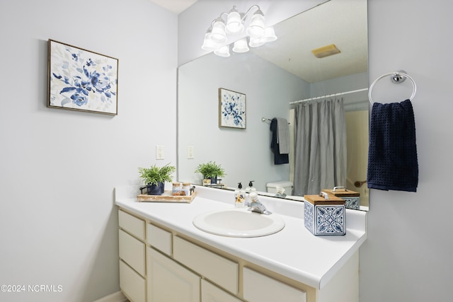 bathroom with toilet, vanity, and a shower with shower curtain