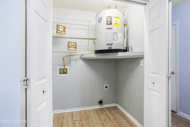 laundry area featuring electric water heater, hardwood / wood-style floors, a textured ceiling, hookup for a washing machine, and hookup for an electric dryer