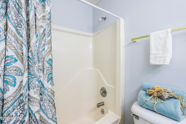 bathroom featuring shower / bath combo with shower curtain and toilet