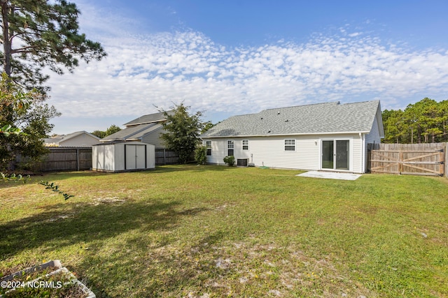 back of property featuring a shed, a patio area, central AC, and a yard