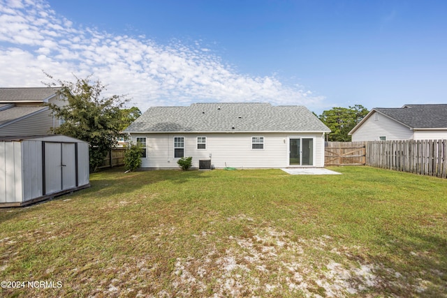 rear view of house featuring a yard, a storage shed, a patio area, and central AC unit