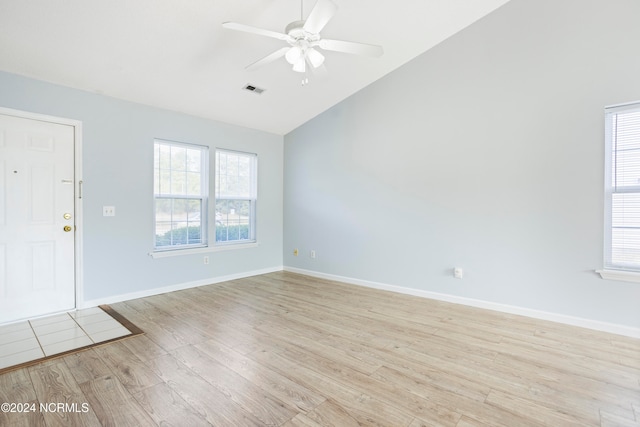 unfurnished room with lofted ceiling, light hardwood / wood-style floors, and plenty of natural light