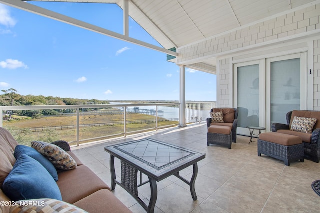 view of patio featuring a water view, outdoor lounge area, and a balcony