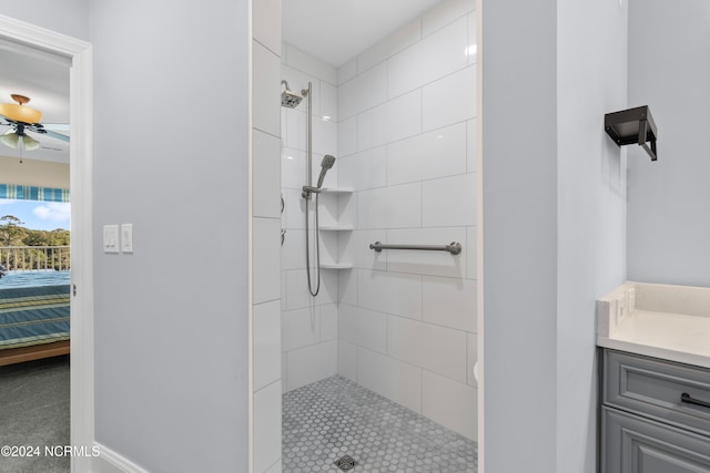 bathroom featuring ceiling fan, vanity, and tiled shower