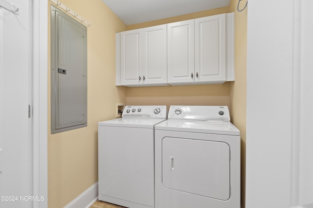 laundry room featuring electric panel, independent washer and dryer, and cabinets