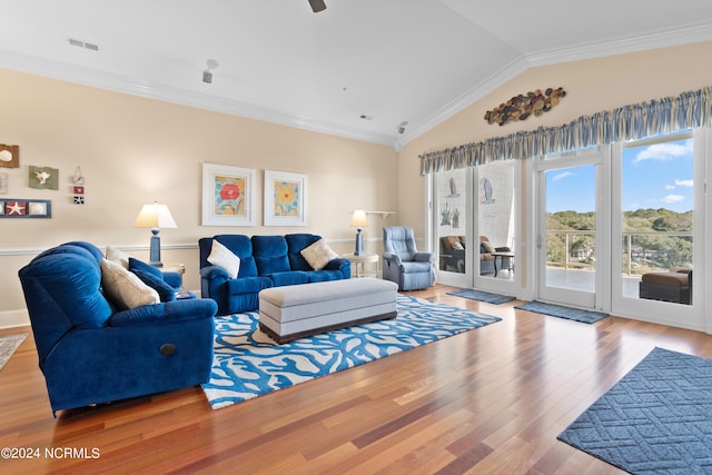 living room with ornamental molding, vaulted ceiling, and light hardwood / wood-style flooring