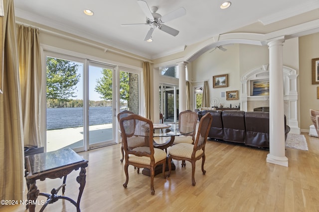 dining room featuring decorative columns, light hardwood / wood-style flooring, a water view, and ceiling fan