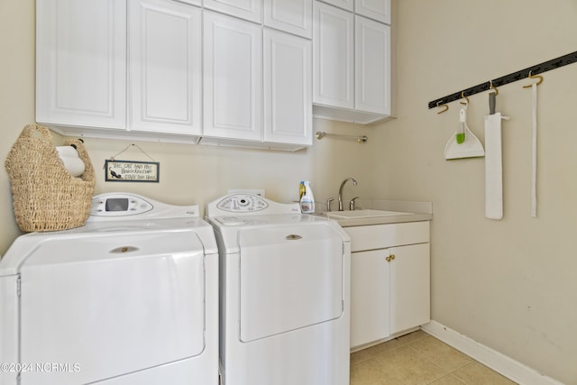 laundry room with sink, washer and clothes dryer, light tile patterned flooring, and cabinets