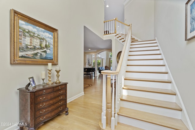 stairway featuring crown molding and hardwood / wood-style flooring