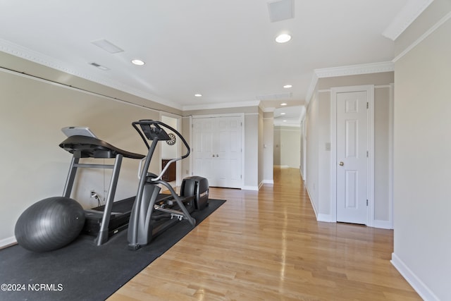 workout room featuring crown molding and hardwood / wood-style flooring