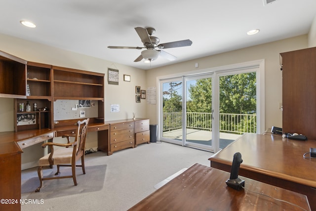 carpeted office with built in desk and ceiling fan