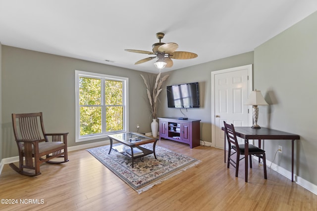 living room with light hardwood / wood-style floors and ceiling fan