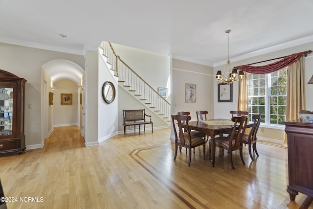 dining area with an inviting chandelier, light hardwood / wood-style flooring, and ornamental molding