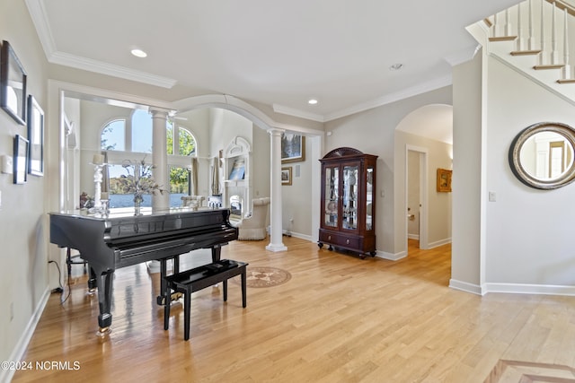 miscellaneous room with decorative columns, light hardwood / wood-style flooring, and crown molding