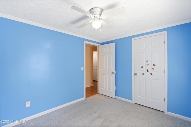 unfurnished bedroom with baseboards, ceiling fan, a textured ceiling, and carpet flooring