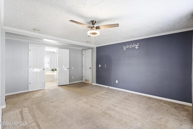 unfurnished room featuring a textured ceiling, ornamental molding, a ceiling fan, and carpet flooring