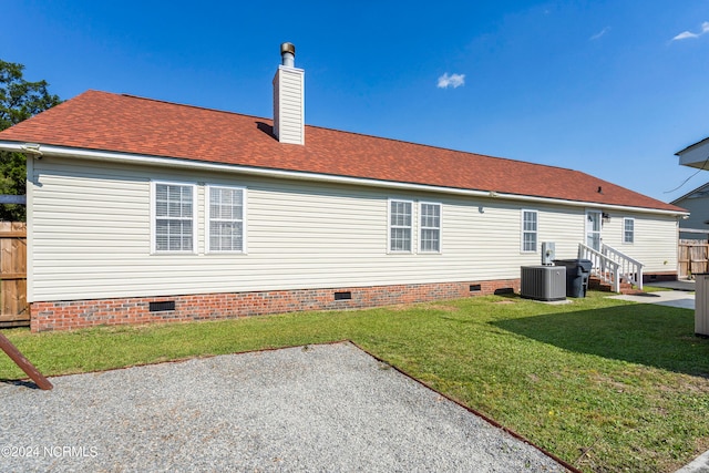 rear view of house with a patio, central AC, and a yard