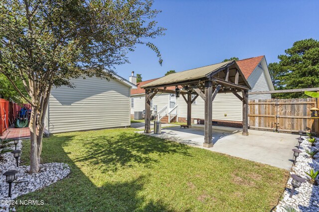 view of yard featuring fence, a gazebo, a patio area, and central air condition unit