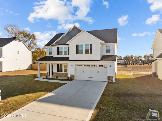 view of front of property with covered porch, a garage, central AC unit, and a front yard