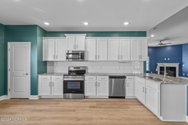 kitchen featuring kitchen peninsula, light hardwood / wood-style flooring, stainless steel appliances, and white cabinets