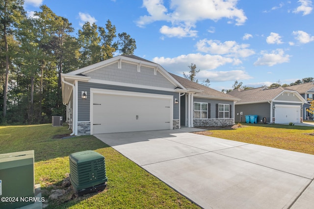 view of front of home featuring a front yard, a garage, and central AC