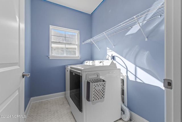 clothes washing area featuring light tile patterned flooring and washer and dryer