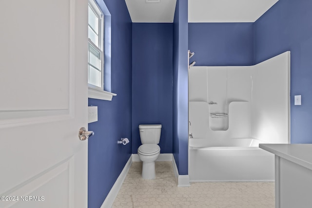 bathroom featuring tile patterned flooring, a washtub, and toilet