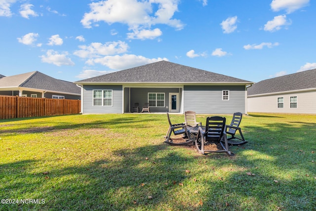 rear view of property featuring a patio and a yard