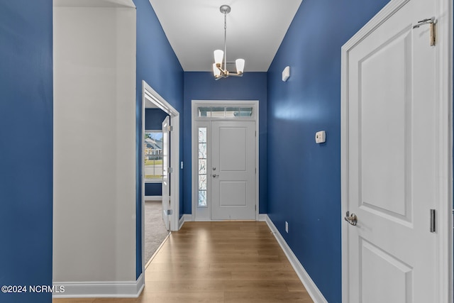 foyer with hardwood / wood-style floors and an inviting chandelier