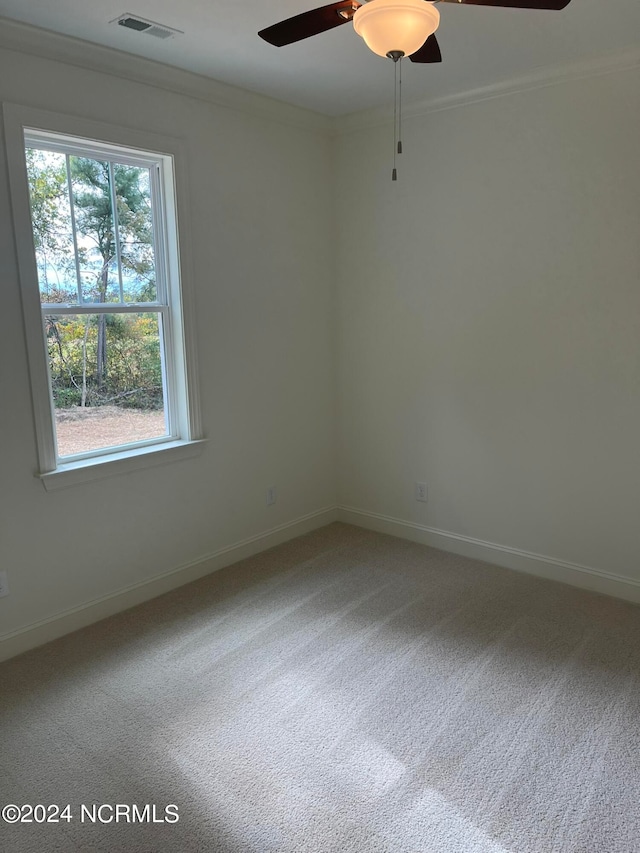 carpeted empty room with ceiling fan and crown molding