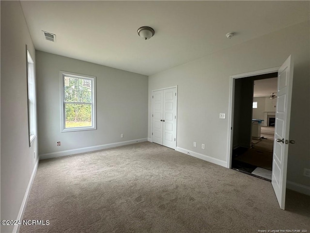 unfurnished bedroom featuring a closet, carpet, and a fireplace