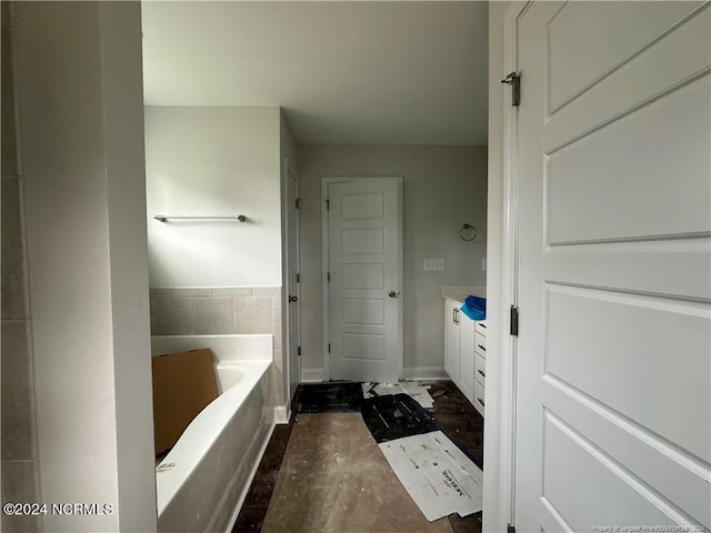 bathroom featuring vanity and a washtub