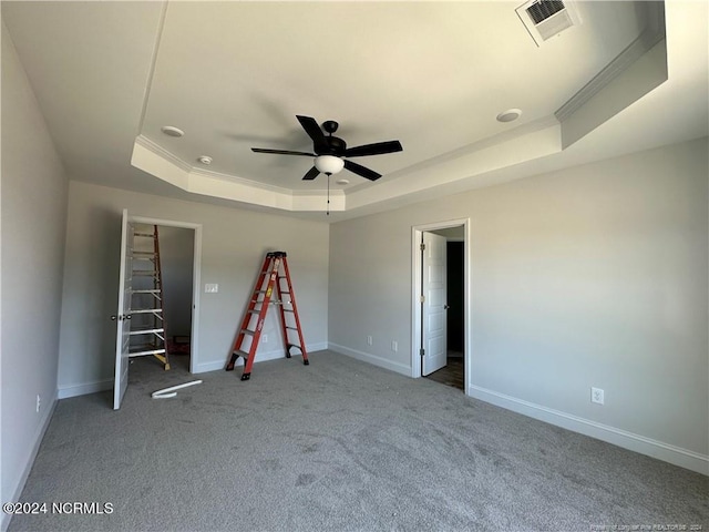 unfurnished bedroom featuring crown molding, ceiling fan, and a raised ceiling